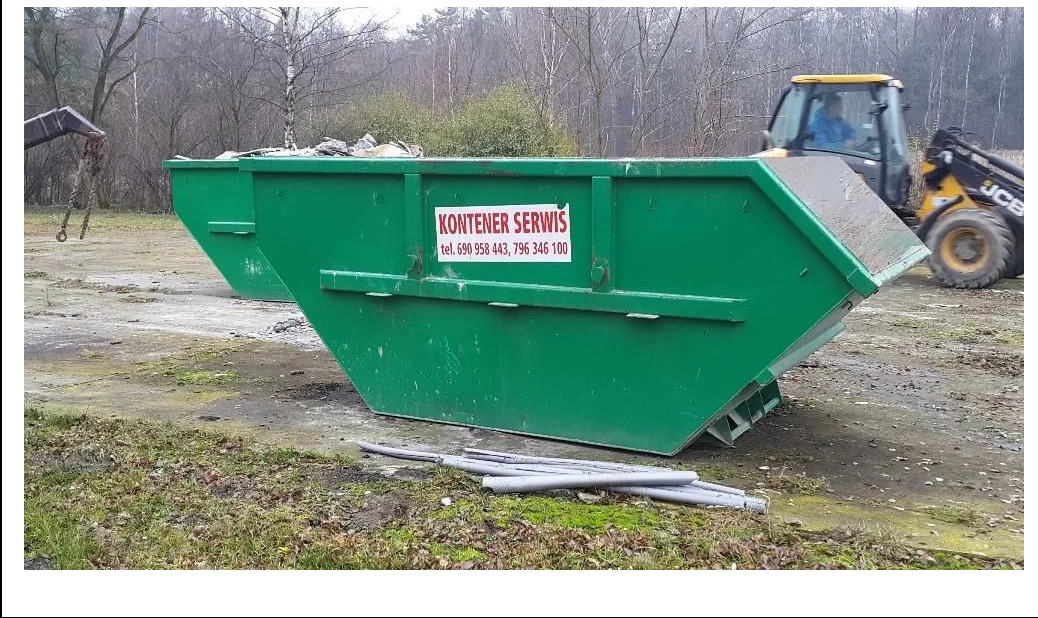 Dwa zielone kontenery na gruz stojące na ziemi, z widocznym logo firmy 'Kontener Serwis' i numerami telefonów. W tle koparka JCB oraz drzewa bez liści.