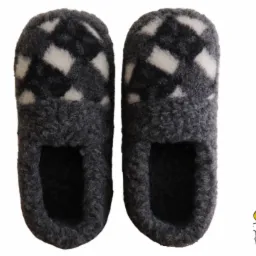 Para szarych, filcowych kapci domowych z białymi rombami, widocznych od przodu, z logo firmy w prawym dolnym rogu.