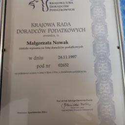 Skan dyplomu Małgorzaty Nowak z Krajowej Izby Doradców Podatkowych, potwierdzający wpis na listę doradców podatkowych w dniu 24.11.1997, z podpisem Przewodniczącej Krajowej Rady Doradców Podatkowych.