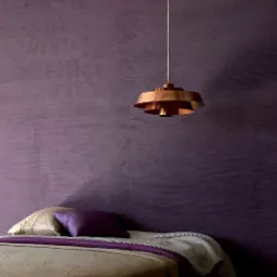 Fioletowa sypialnia z miedzianą lampą wiszącą, dekoracyjna faktura ściany, łóżko z poduszkami w odcieniach fioletu i beżu.
