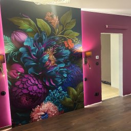 UBERR Renata Rakowska - Kwiatowa fototapeta na ścianie w Markach, oświetlona kinkietami, tworzy unikalny akcent w pomieszczeniu z bordowymi ścianami i drewnianą podłogą.