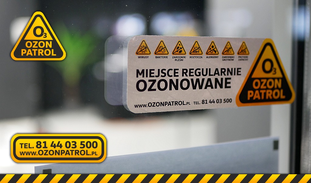 Naklejka informująca o regularnym ozonowaniu pomieszczenia z logo Ozon Patrol, ostrzegająca przed wirusami, bakteriami, zarodnikami pleśni, roztoczami, alergenami i przykrymi zapachami, umieszczona...