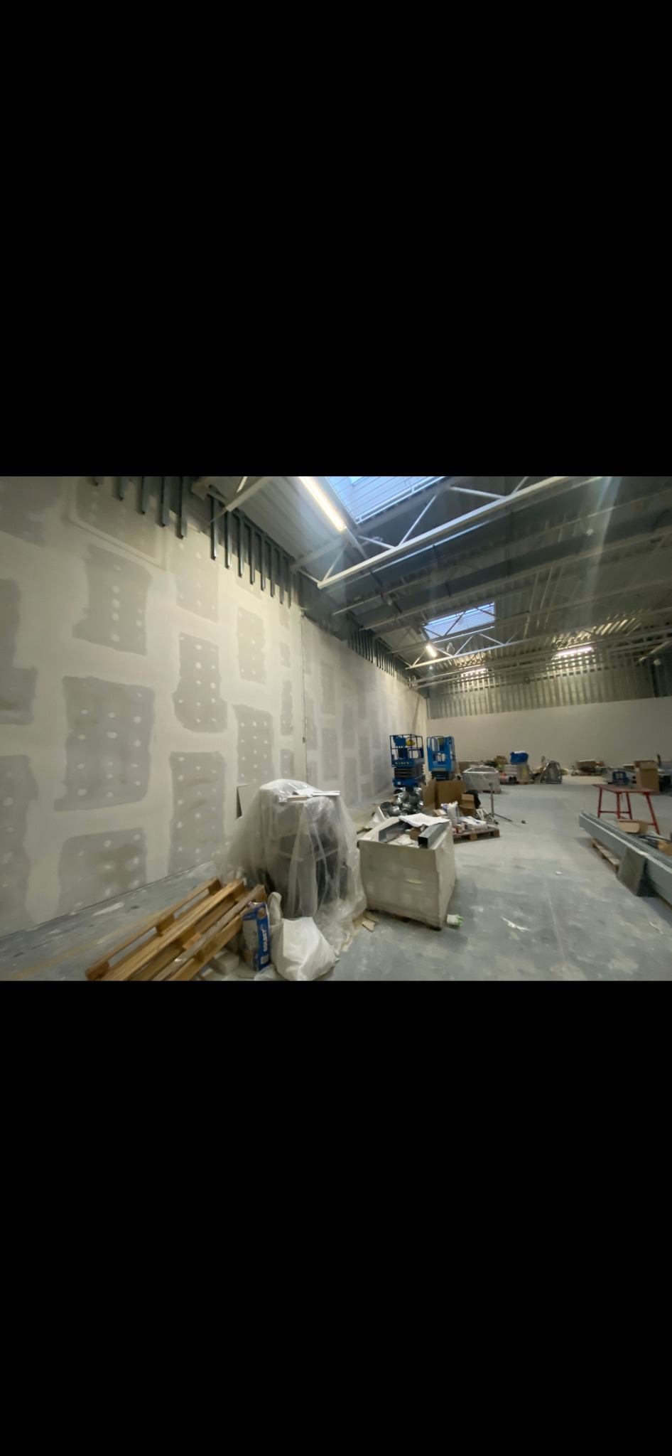 Prace wykończeniowe w obiekcie wielkopowierzchniowym – przygotowanie ścian pod malowanie i docelowe aranżacje.