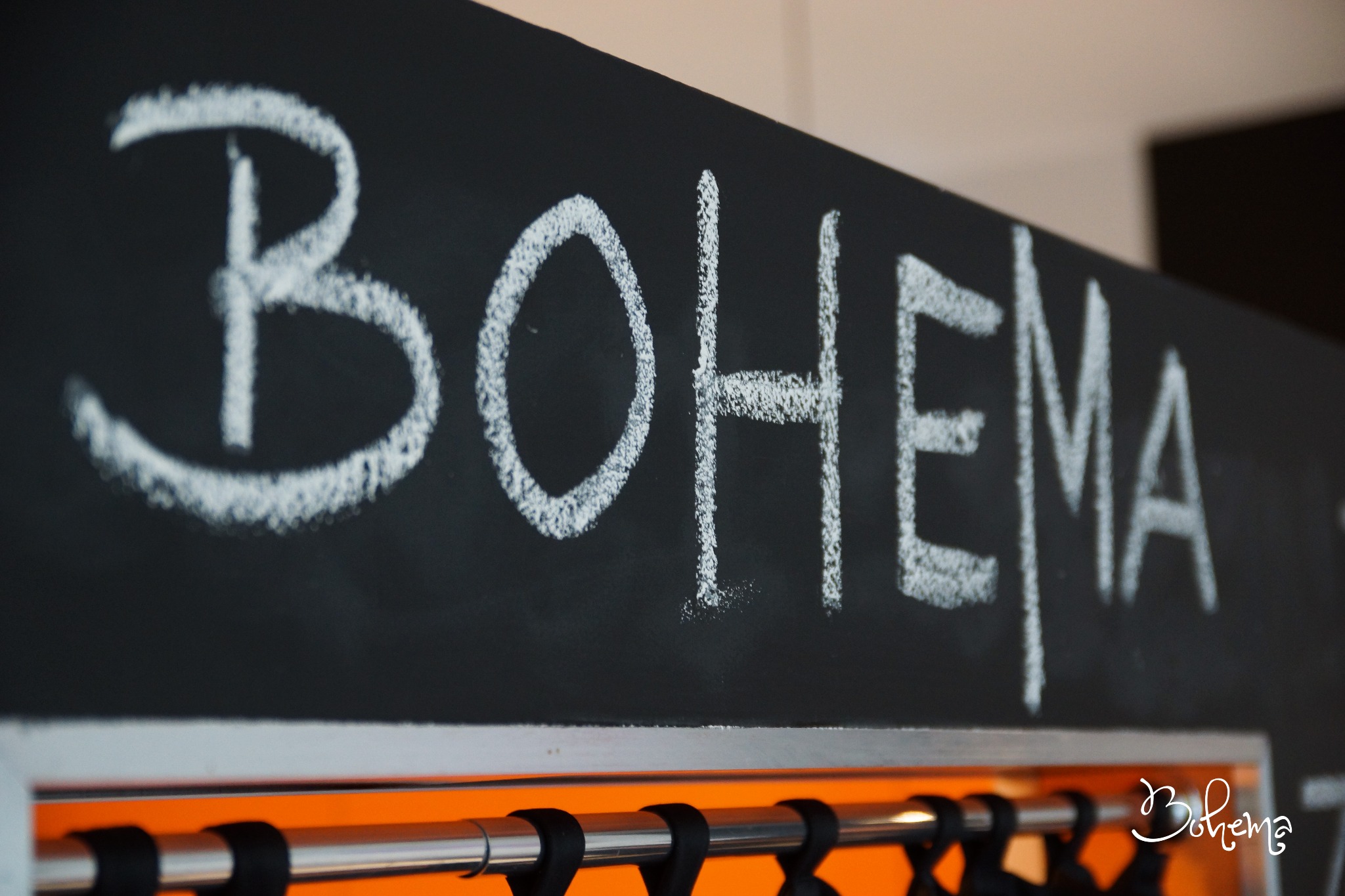 Tablica z napisem 'BOHEMA' wykonanym kredą, widoczna w Płocku, prawdopodobnie element dekoracji lub szyld sklepu.