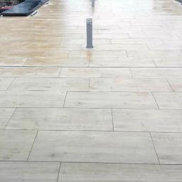 SW Projekt - Płaski dach pokryty jasnymi płytami imitującymi drewno, z dwoma pionowymi szarymi elementami wentylacyjnymi, widok z okna.