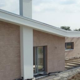 SW Projekt - Nowoczesny dom jednorodzinny z elewacją w kolorze piaskowym, widoczne detale wykończenia, elementy konstrukcyjne i przygotowane podłoże pod taras.