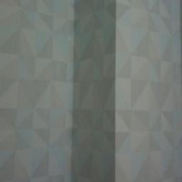 SW Projekt - Wnętrze pokoju z szarą tapetą o geometrycznym wzorze trójkątów i kwadratów, widoczny fragment narożnika ściany.