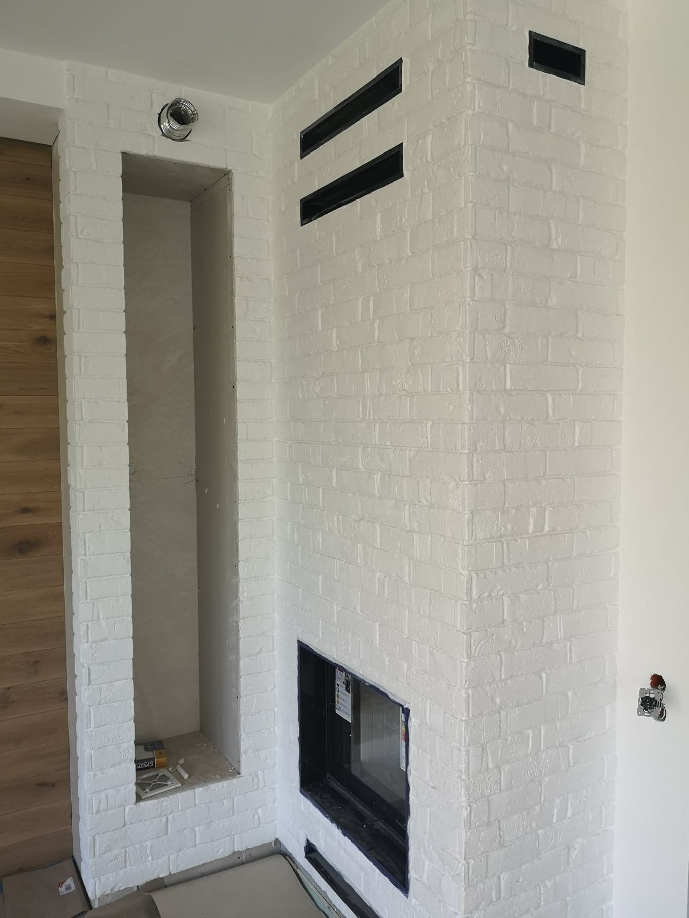 Obudowa kominka oraz wnęki na drewno płytkami gipsowymi z fugą