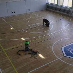 Renowacja sali sportowej - cyklinowanie, malowanie linii oraz herbu szkoły.