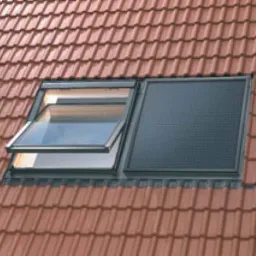 Czerwony dach z dachówki ceramicznej z oknem dachowym uchylonym i panelem solarnym wbudowanym w połać dachu.