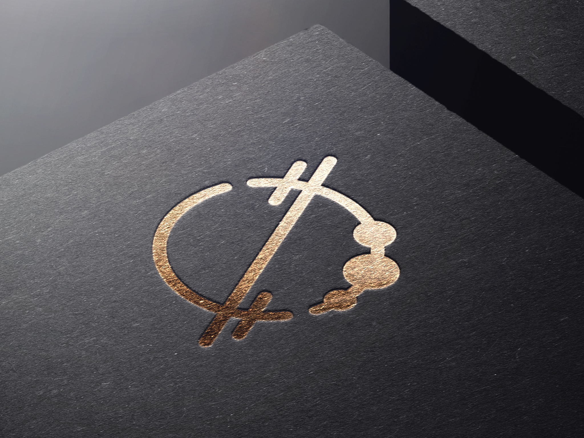 Złote logo na czarnym, teksturowanym papierze, z wyraźnym światłocieniem podkreślającym fakturę papieru i detale wzoru.