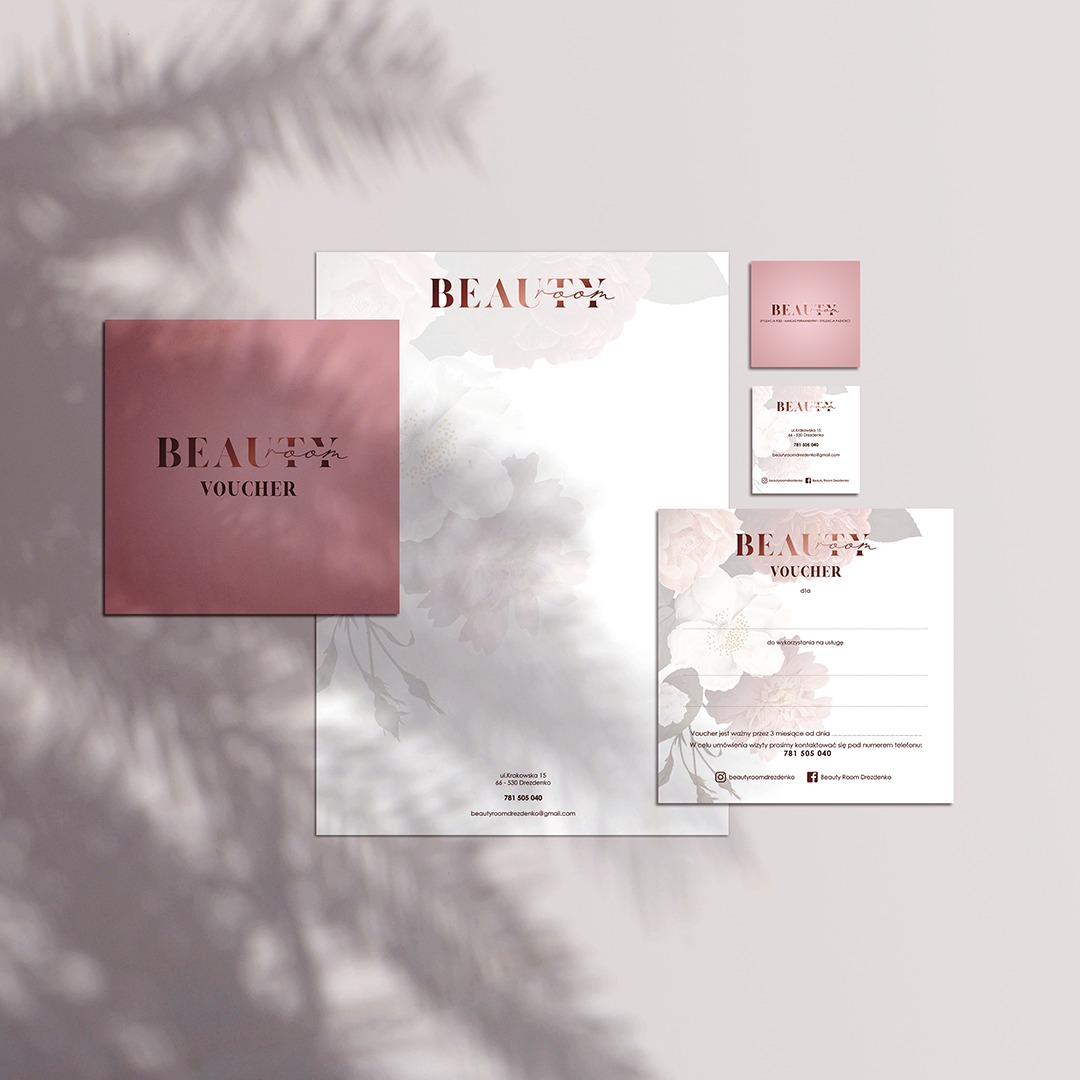Komplet materiałów identyfikacji wizualnej Beauty Room: wizytówka, voucher, papier firmowy, utrzymane w stylistyce różowego złota z motywem kwiatowym, ocienione liśćmi.