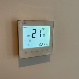 HEAT AT HOME SP. Z O.O. - Cyfrowy termostat ścienny marki Heat-On, ustawiony na 21 stopni Celsjusza, wyświetlający trzeci tydzień i godzinę 02:44.