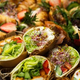 Top Party Box Sp. z o.o. - Box cateringowy z wrapami i croissantami, udekorowany świeżymi ziołami i truskawkami. Elegancki zestaw lunchowy z dostawą w Poznaniu.