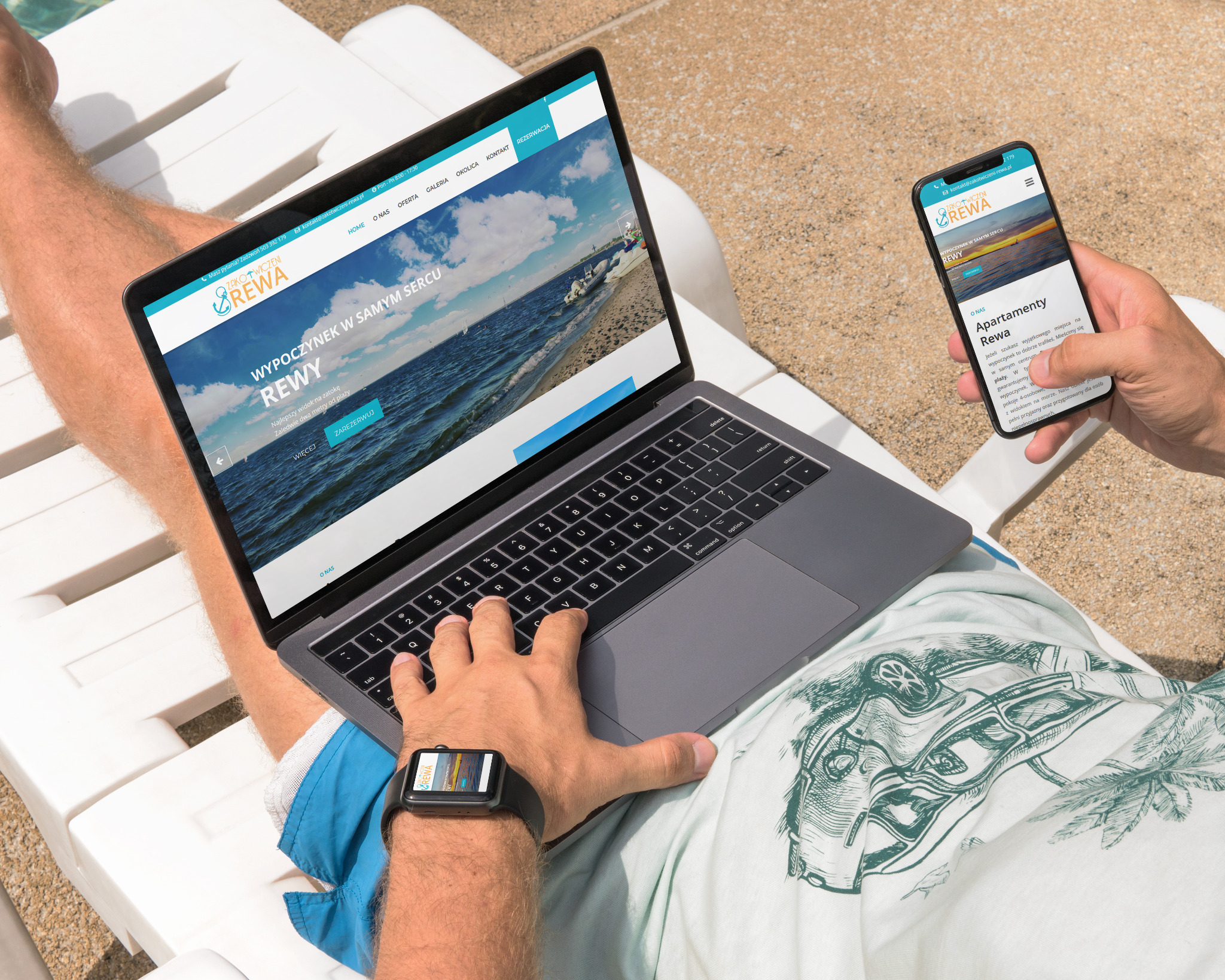 Mężczyzna relaksuje się na leżaku, przeglądając stronę internetową Zakotwiczeni Rewa na laptopie i smartfonie. Na ekranach widoczne zdjęcia morza i plaży. Na nadgarstku smartwatch z wyświetloną...