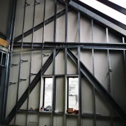 Konstrukcja szkieletowa ścian działowych z profili stalowych, widoczne otwory okienne, izolacja z płyt warstwowych, budowa poddasza.