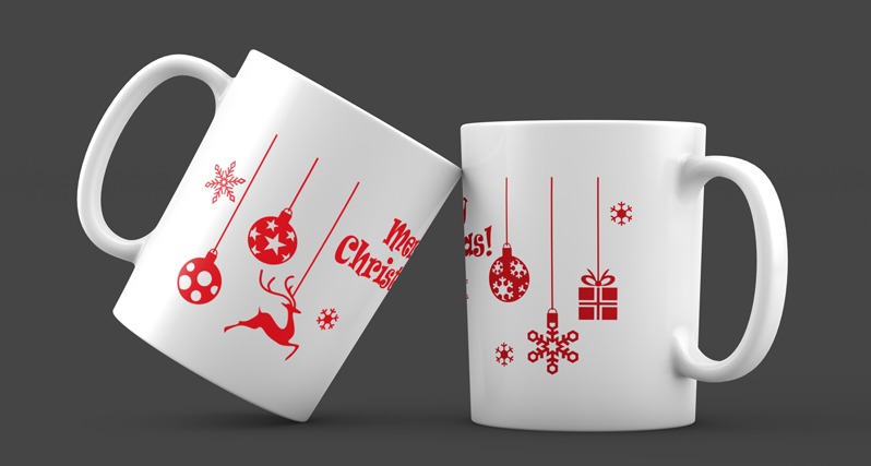 Dwa białe kubki z czerwonymi, świątecznymi nadrukami: bombki, renifer, śnieżynki i napis 'Merry Christmas!', ustawione na szarym tle.