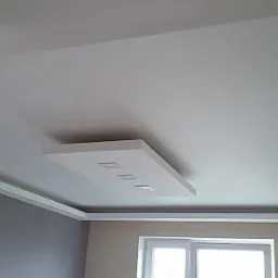 Biały sufit podwieszany z prostokątną wnęką i trzema punktami świetlnymi, widok z dołu