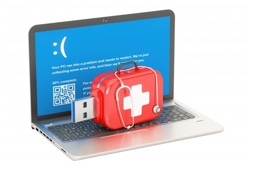 Laptop z niebieskim ekranem śmierci, czerwona apteczka z stetoskopem i pendrive wetknięty w port USB, symbolizujące ratowanie danych z uszkodzonego komputera.