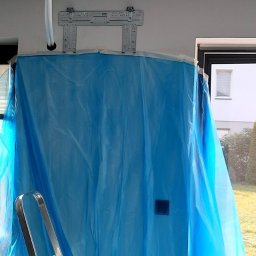 Ergo-klima Tomasz Menzel - Przygotowania do montażu jednostki wewnętrznej: zamontowany uchwyt, rury wyprowadzone przez ścianę, zabezpieczenie folią malarską, drabina oparta o ścianę.