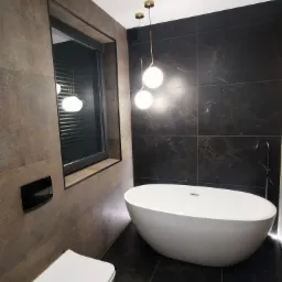 Nowoczesna łazienka z wolnostojącą białą wanną, czarną armaturą i kulistymi lampami wiszącymi na złotych prętach, brązowe i czarne płytki na ścianach i podłodze, okno z żaluzjami.