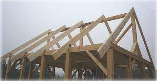 Konstrukcja dachu z drewna, widoczne krokwie i elementy więźby, surowe drewno, szkielet dachu w trakcie budowy, jasne oświetlenie, etap budowy domu.