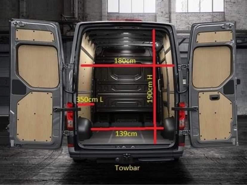 Wnętrze furgonetki z otwartymi drzwiami, wyłożone sklejką, z zaznaczonymi wymiarami: wysokość 190cm, szerokość 180cm, długość 350cm i głębokość 139cm, widoczny hak holowniczy.
