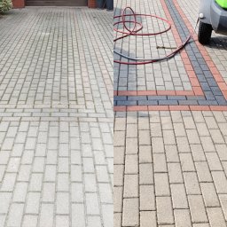 DACHY-ELEWACJE Wojciech Chomiak - Efekt przed i po czyszczenia kostki brukowej na podjeździe. Połowa powierzchni wyczyszczona, ukazując różnicę w kolorze i usunięciu zabrudzeń. Widoczny wąż i fragment urządzenia.