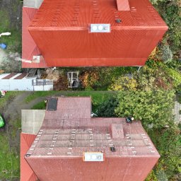 DACHY-ELEWACJE Wojciech Chomiak - Z lotu ptaka: Dwa budynki z czerwonymi, trapezowymi dachami blachodachówkowymi, otoczone zielenią. Na jednym dachu widoczny pracownik w kasku. Widoczne kominy i elementy wentylacji.