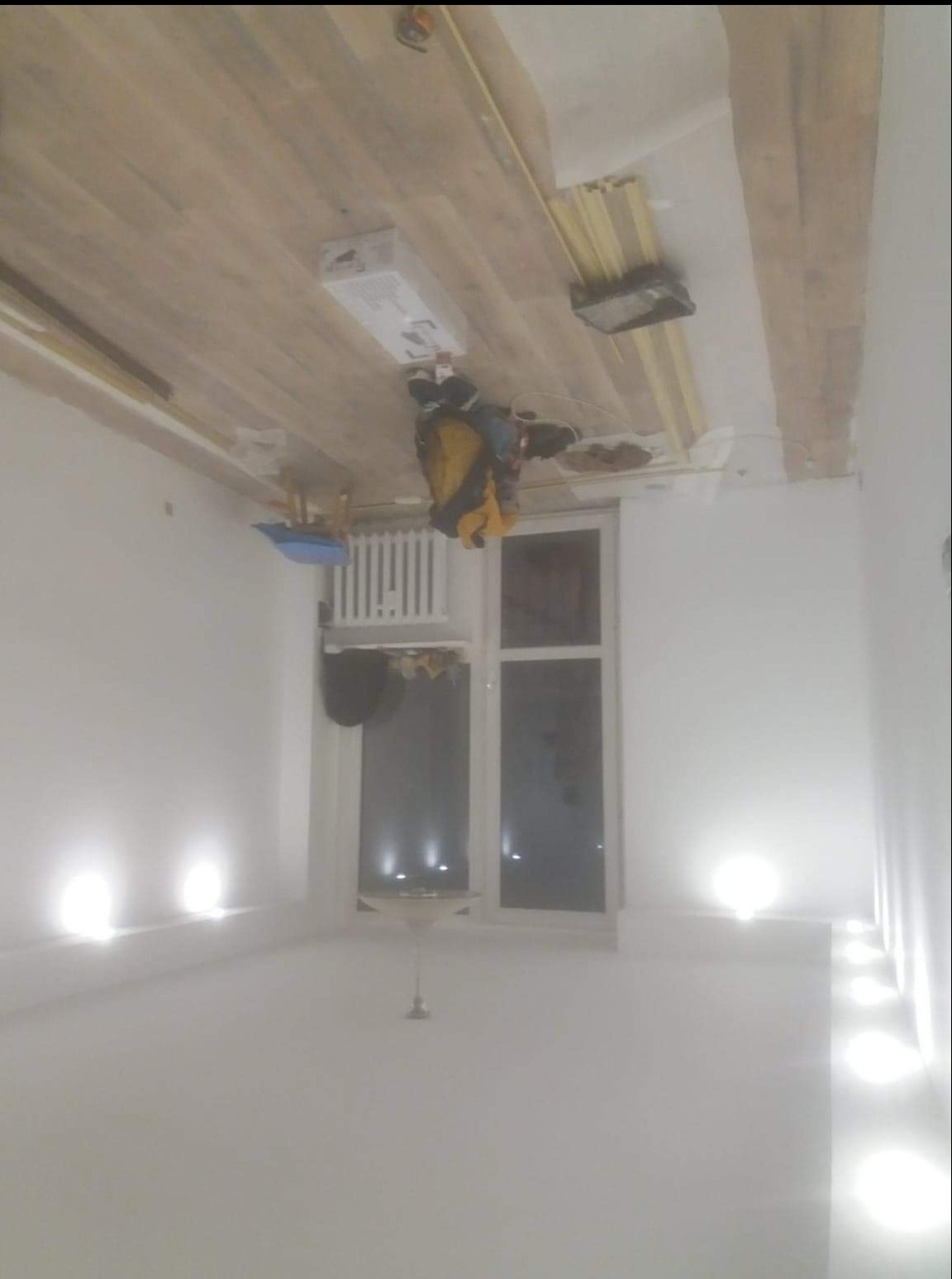 Przygotowania do montażu sufitu napinanego: widoczne profile na suficie, narzędzia i materiały w pomieszczeniu z oświetleniem punktowym.