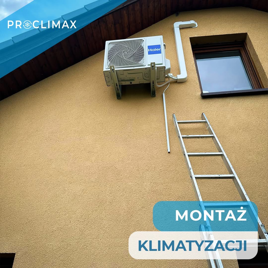 Zamontowana jednostka zewnętrzna klimatyzacji Haier na elewacji domu, widoczna drabina i rury instalacyjne. Ujęcie z dołu, jasne oświetlenie.