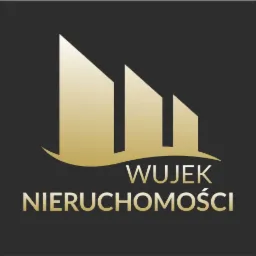Złote logo firmy Wujek Nieruchomości na ciemnym tle, przedstawiające stylizowane budynki.