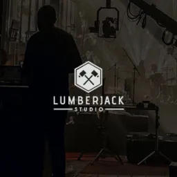 Logo Lumberjack Studio na tle sceny koncertowej z muzykami i sprzętem oświetleniowym, widoczne sylwetki osób.