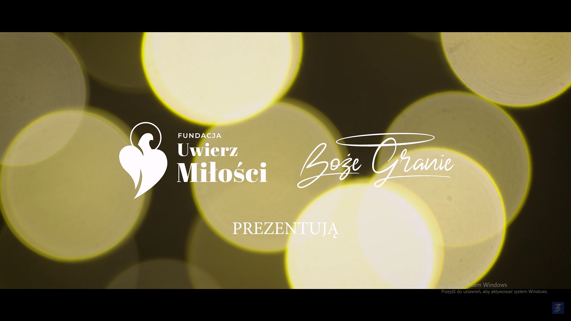 Plansza tytułowa filmu Fundacji Uwierz Miłości, prezentująca napis 'Boże Granie' na tle rozmytych, ciepłych świateł.