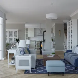 Przestronny salon w odcieniach bieli i błękitu z parkietem w jodełkę, pianinem i otwartą kuchnią w tle.