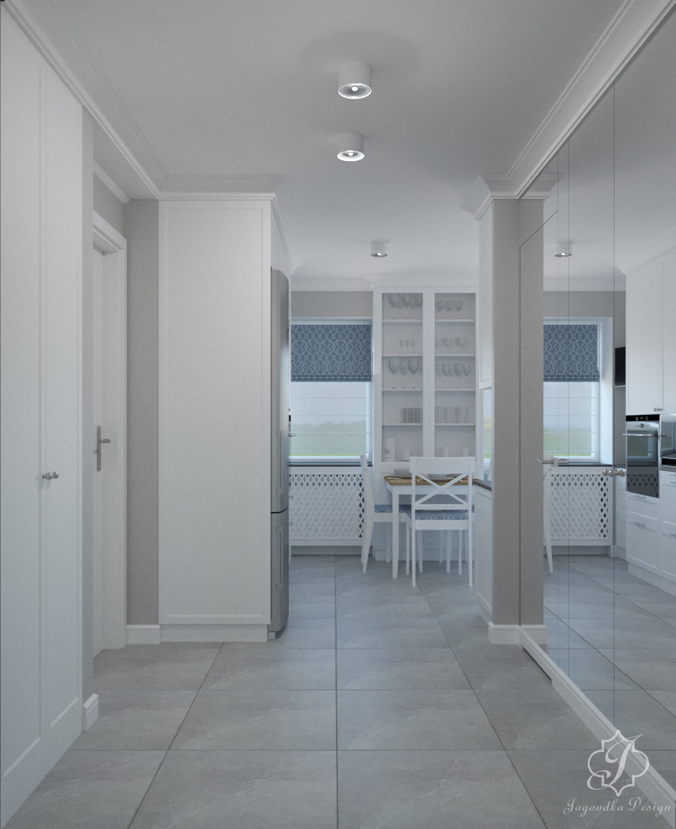 Wnętrze kuchni w stylu klasycznym z szarymi płytkami podłogowymi, białymi meblami, okrągłym stołem z krzesłami i zasłonami w niebieski wzór, widoczne przez przeszkloną ścianę.