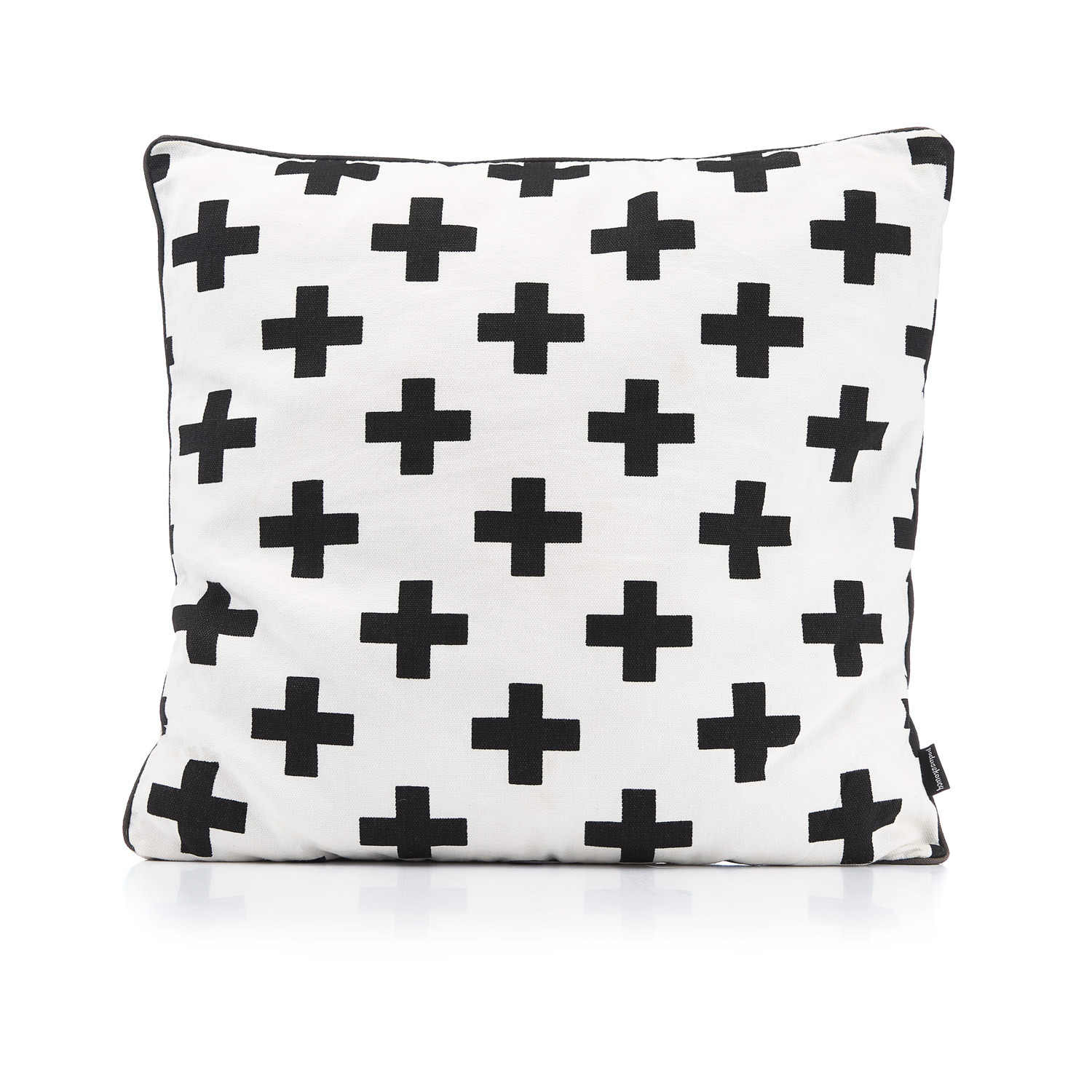 Kwadratowa poduszka dekoracyjna z białego materiału w czarne krzyże, z ciemną lamówką, leżąca na białym tle z odbiciem.