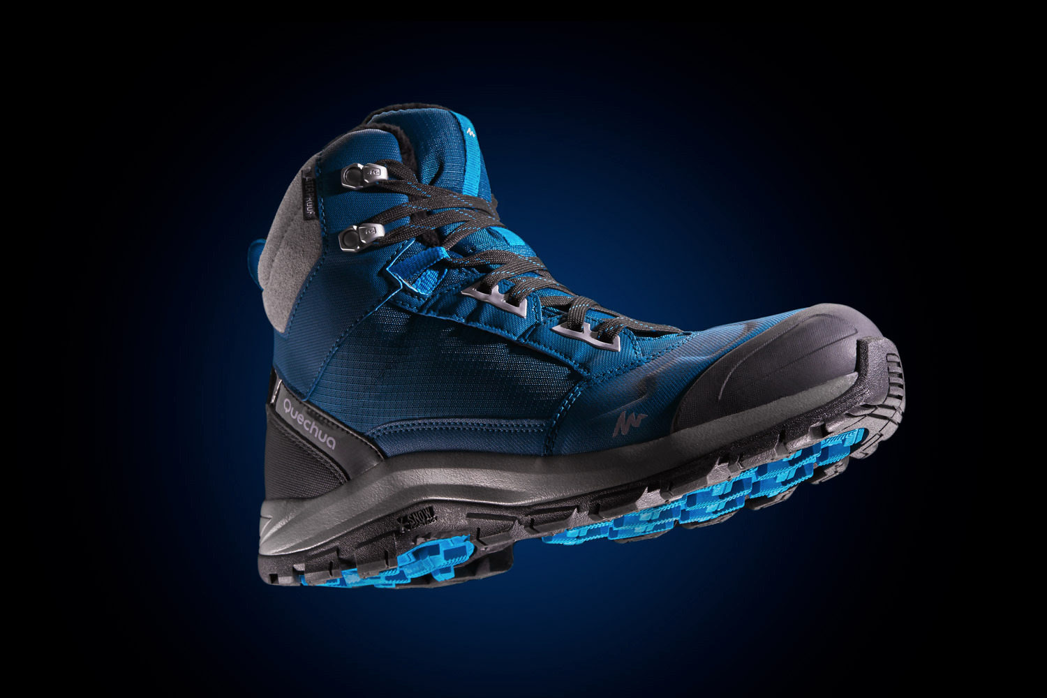 Pojedynczy, niebieski but trekkingowy marki Quechua z szarą wyściółką i czarną podeszwą z niebieskimi elementami, unoszący się na ciemnym tle.