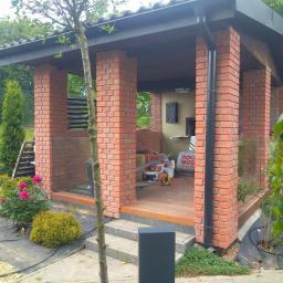 Ar3i bud Artur Kurdziel - Murowana altana z cegły, drewniana podłoga w trakcie budowy, widoczne materiały izolacyjne i narzędzia.