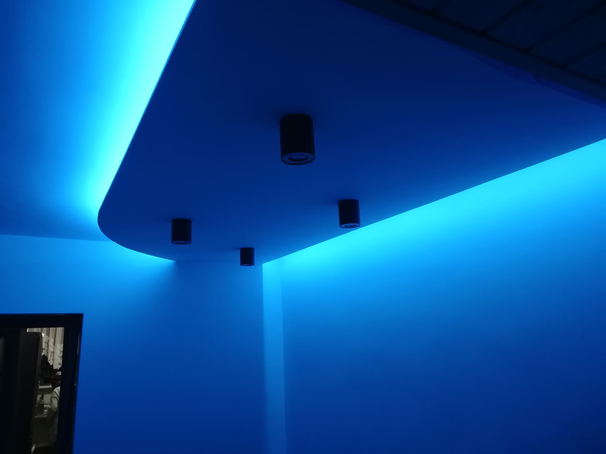 Niebieskie oświetlenie LED podsufitowe z czarnymi punktowymi lampami, widok z dołu, nowoczesny design.