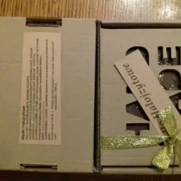 Otwarty kartonik z mydłem halojzytowym, widoczna etykieta ze składem i ozdobna wstążka z kokardką.