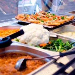 Bufet z różnorodnymi daniami: kotlety z pieczarkami i warzywami, marchewka, kalafior, zielona fasolka szparagowa, gulasz warzywny i zupa krem.