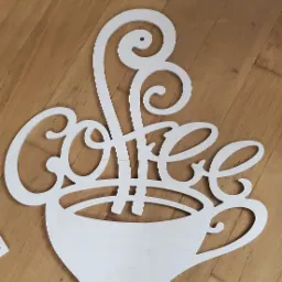 Dekoracja ścienna z jasnego drewna w kształcie filiżanki z napisem 'Coffee' na drewnianej podłodze.