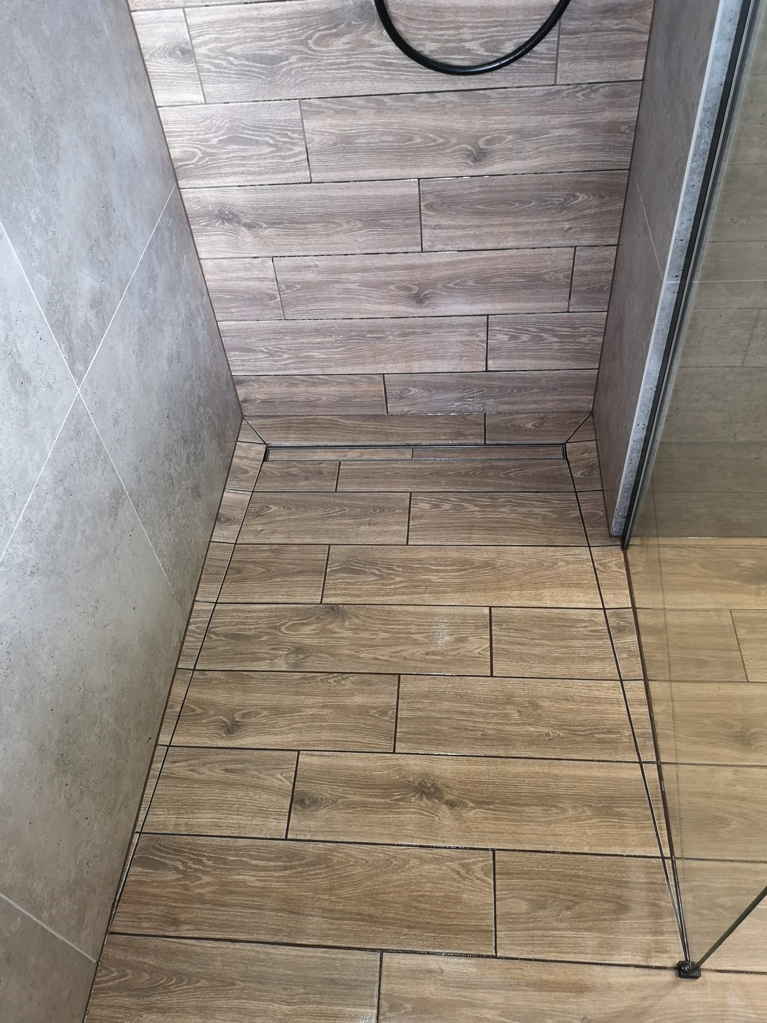 Przestrzeń prysznicowa odpływu liniowego. Gres drewnopodobny.