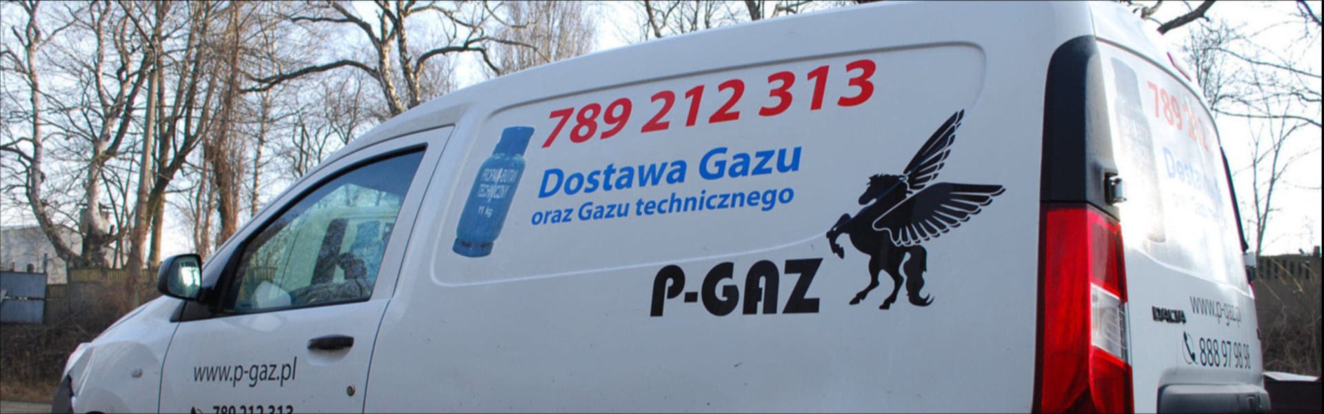 Biały samochód dostawczy z numerem telefonu, adresem strony internetowej i logo firmy dostarczającej gaz techniczny oraz naklejką z niebieską butlą gazową.