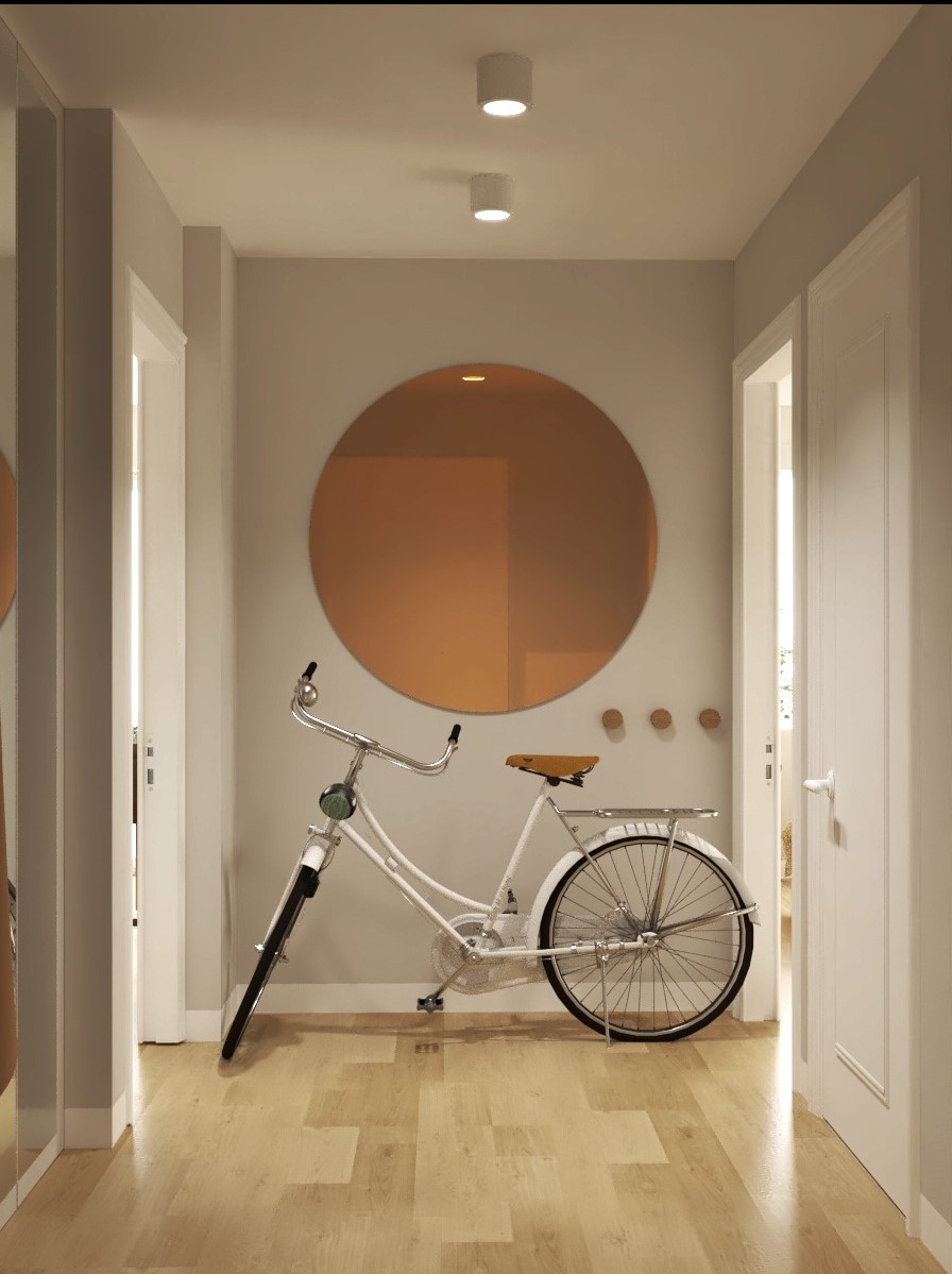 Korytarz w minimalistycznym stylu z okrągłym miedzianym lustrem, białym rowerem retro i drewnianą podłogą.