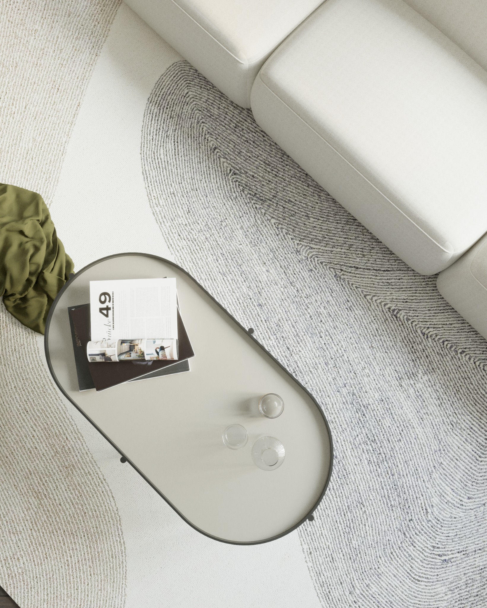 Widok z góry na nowoczesny salon z kremową sofą, owalnym stolikiem kawowym z magazynami i szklanymi naczyniami, oraz wzorzystym dywanem w odcieniach bieli i szarości.