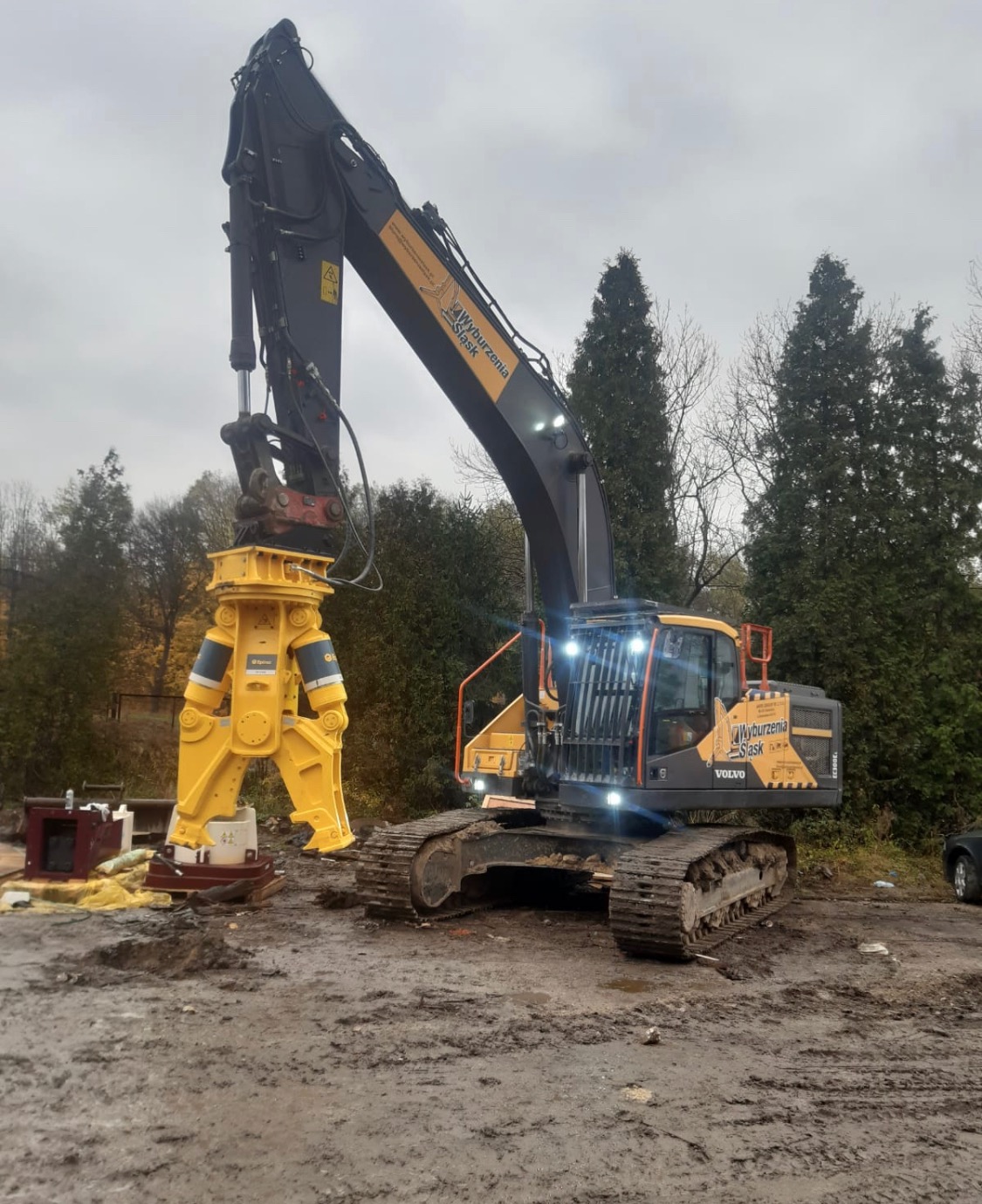 Ciężka maszyna budowlana Volvo EC300EL z hydraulicznymi nożycami do kruszenia betonu, gotowa do pracy na placu budowy w pochmurny dzień.