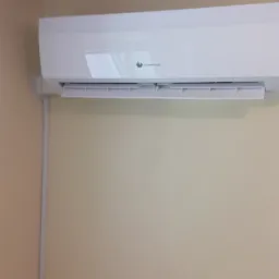 Biały klimatyzator marki Saunier Duval zamontowany na beżowej ścianie w pomieszczeniu, widoczne logo producenta.