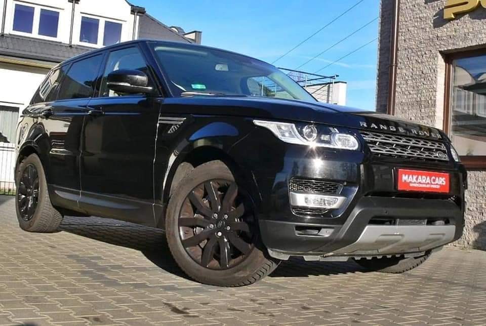 Czarny Range Rover z czarnymi felgami zaparkowany na brukowanej ulicy, z widocznym logo 'Makara Cars' na przedniej szybie, budynek w tle.